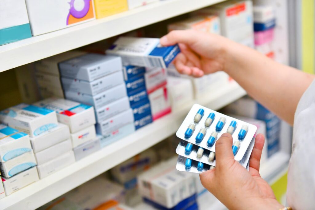 a pharmacist stocking pharmaceutical pills
